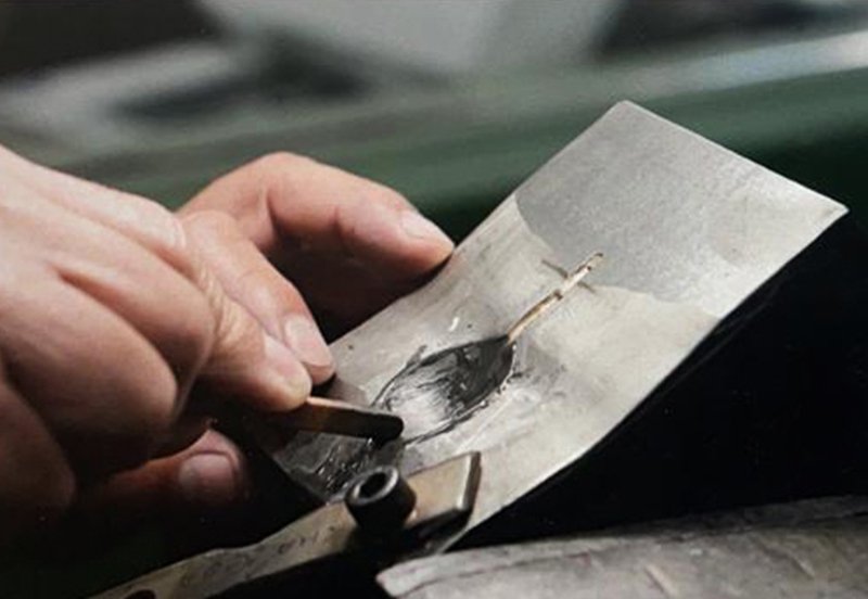Craftsman hand-finishing a stainless steel spoon at Agam Industries